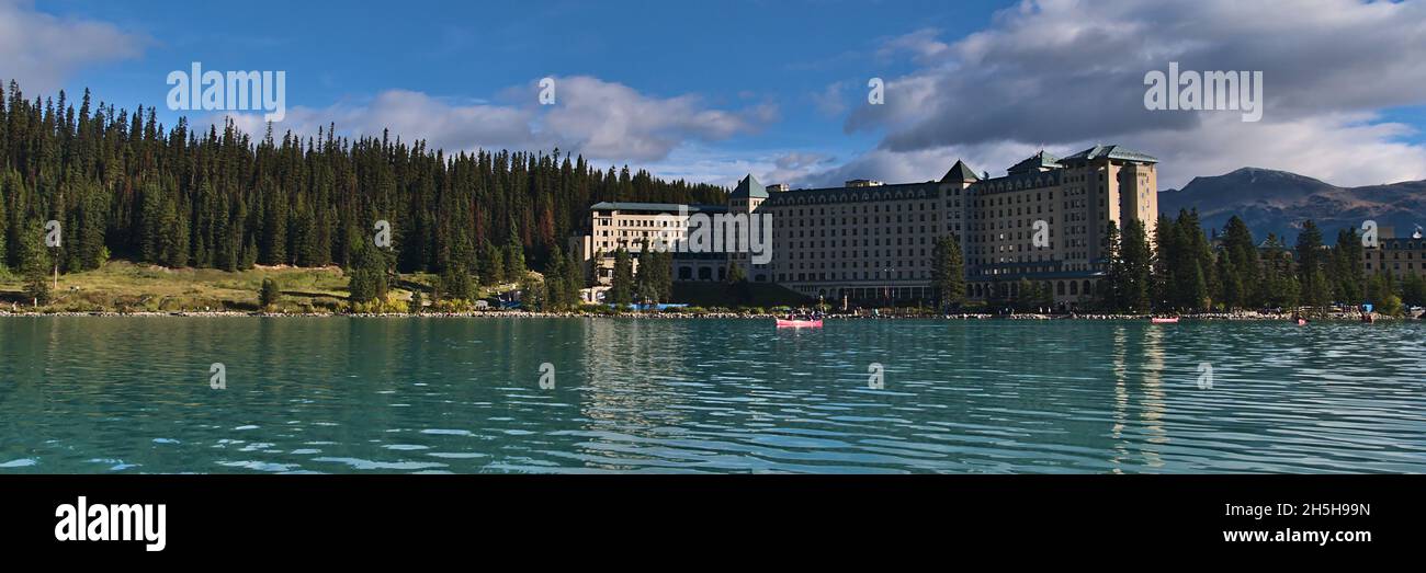 Vue panoramique sur la rive est du lac Louise, dans le parc national Banff, Alberta, Canada, dans les montagnes Rocheuses, avec un hôtel et des canoës célèbres. Banque D'Images
