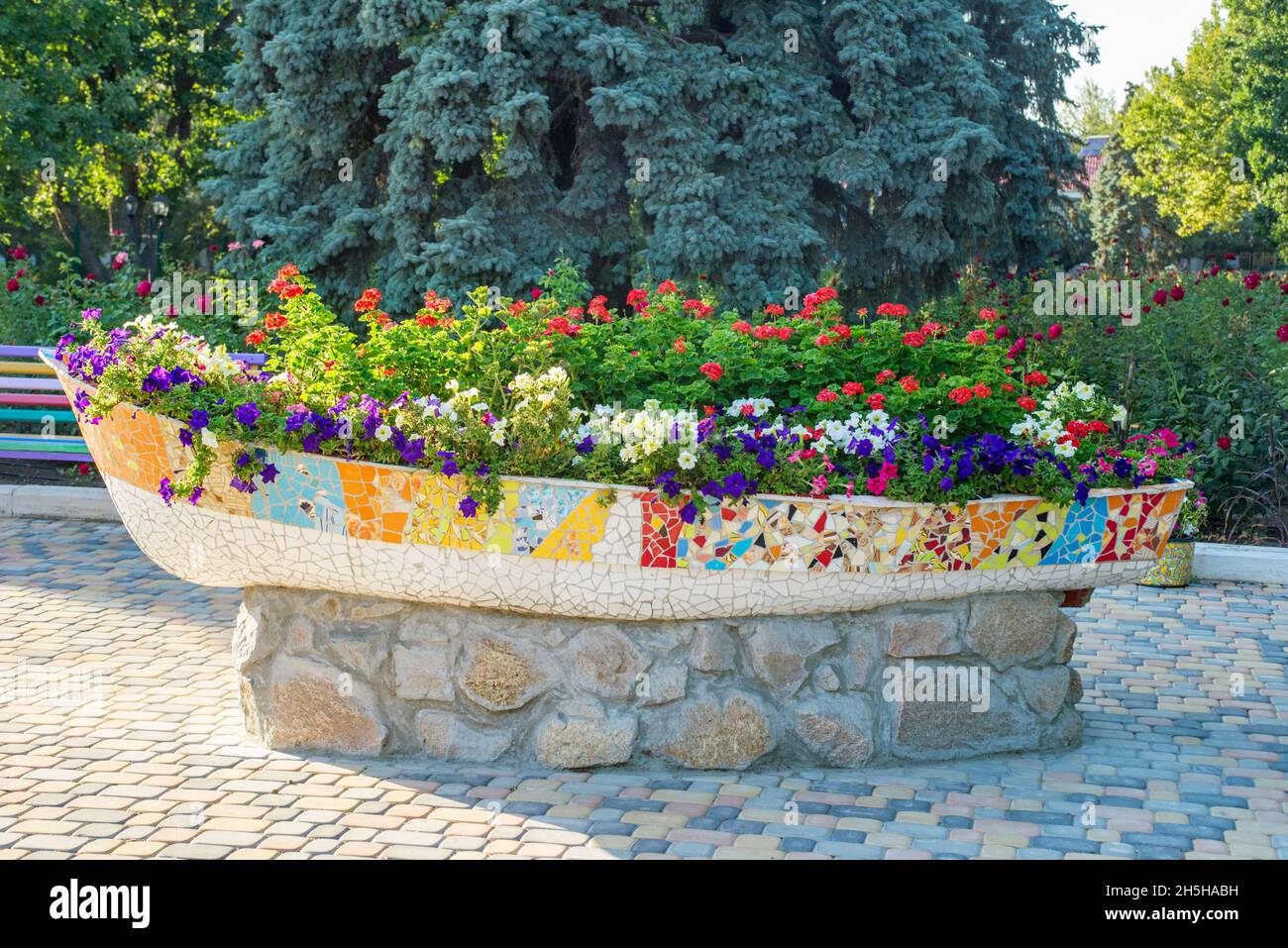 Un grand pot de fleurs dans la rue.La rue fleurit dans un pot de pierre en forme de bateau Banque D'Images