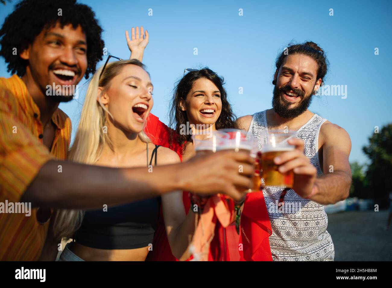 Groupe d'amis heureux qui traînaient et dégusaient des boissons, festival Banque D'Images