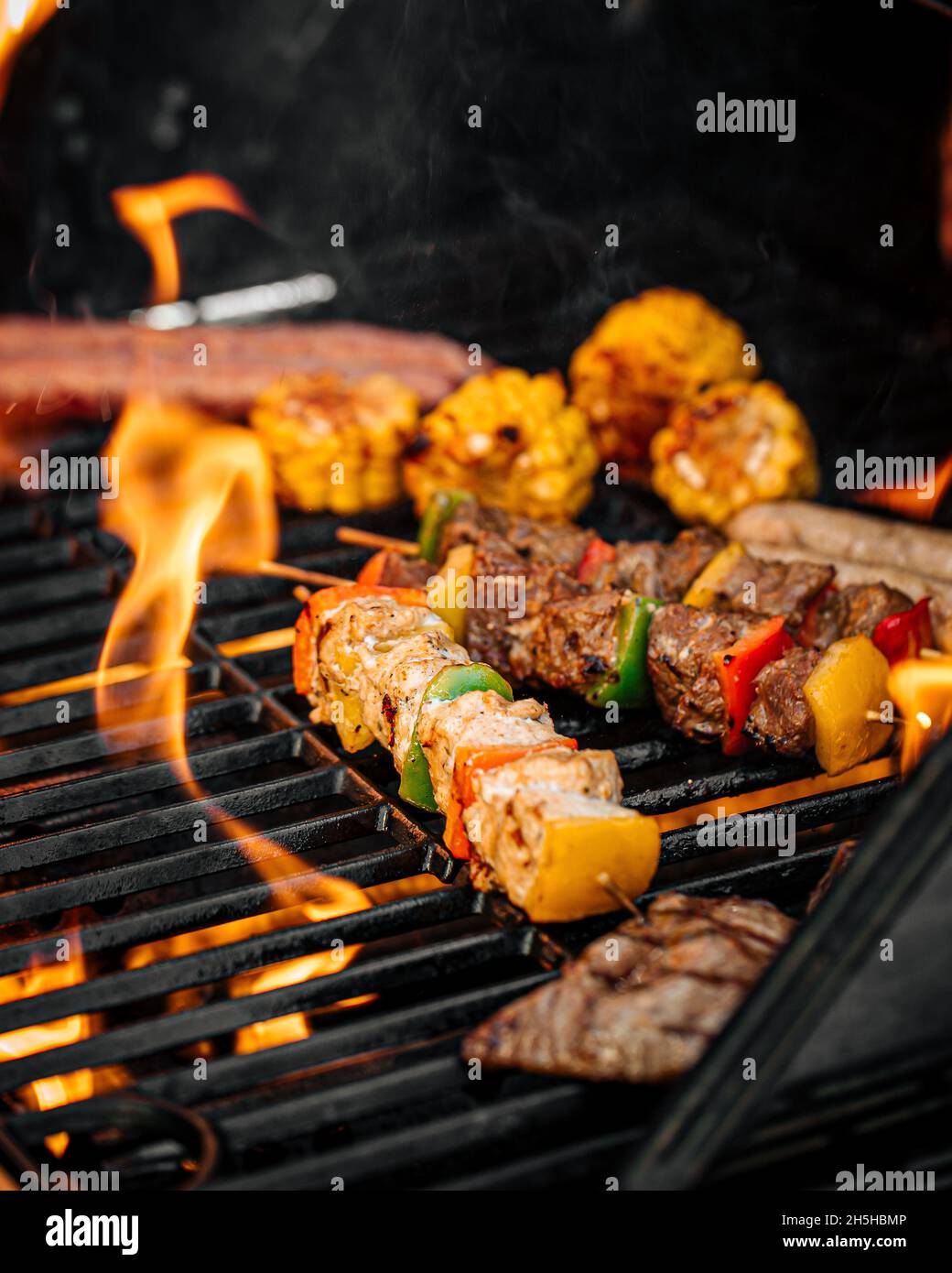 Griller des saucisses et de la viande à la flamme Banque D'Images