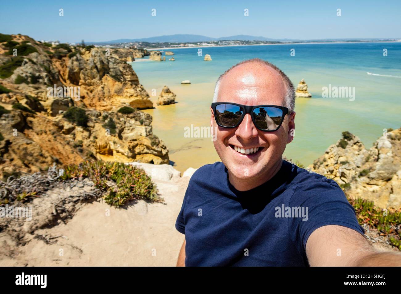 Touriste prenant photo de lui-même à la célèbre Ponta da Piedade, Algarve, Portugal Banque D'Images