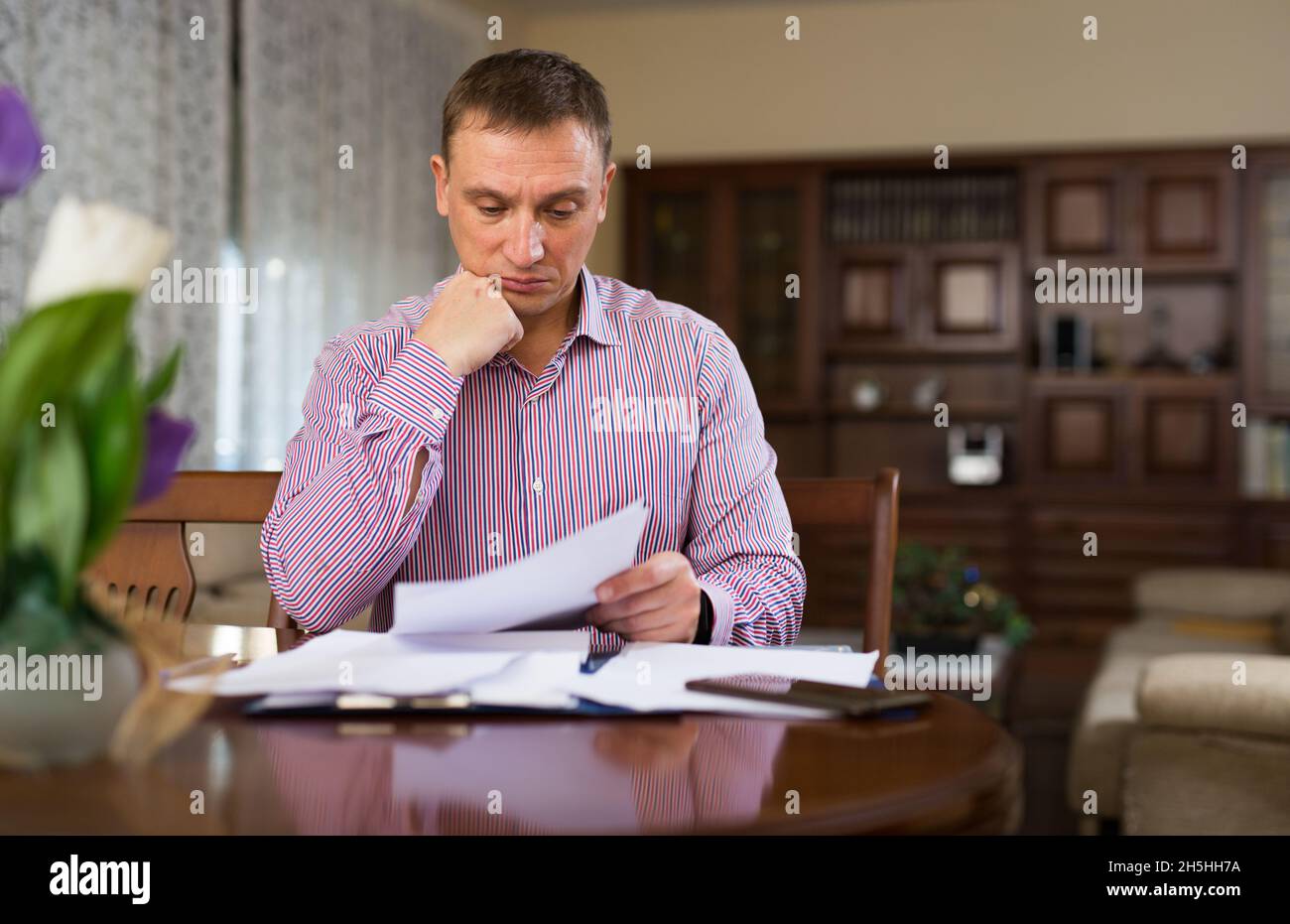 Triste homme frustré à à bout de papier à la table Banque D'Images