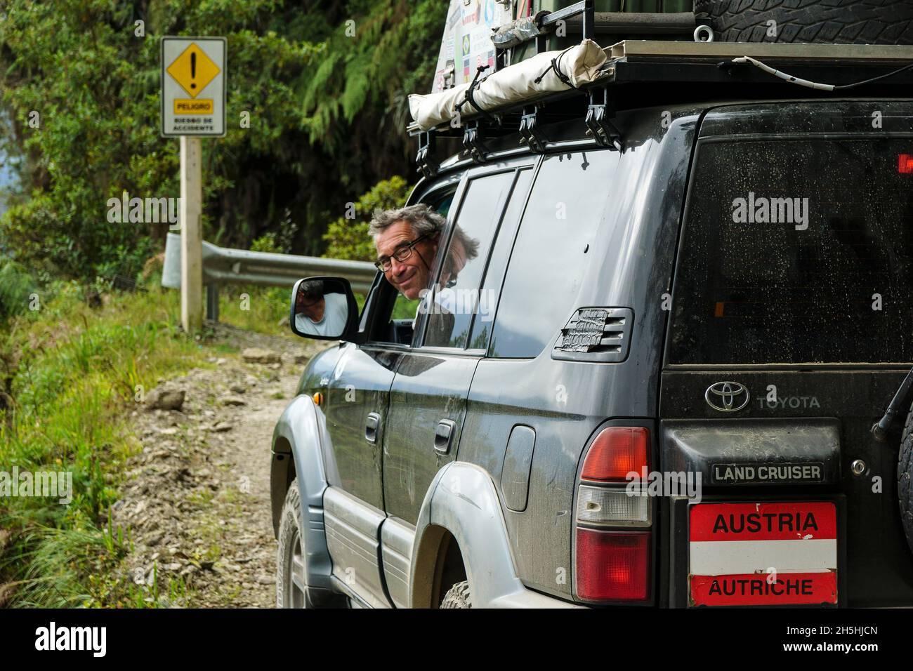 Conducteur souriant d'un véhicule tout-terrain, Toyota Land Cruiser, sur la route de la mort, Camino de la Muerte, département de la Paz, Bolivie Banque D'Images