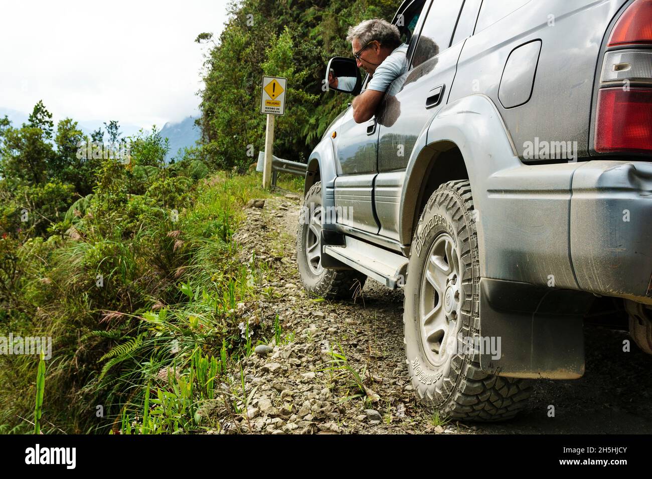 Le conducteur vérifie la route dans un véhicule tout-terrain, Toyota Land Cruiser, sur la route de la mort, Camino de la Muerte, département de la Paz, Bolivie Banque D'Images