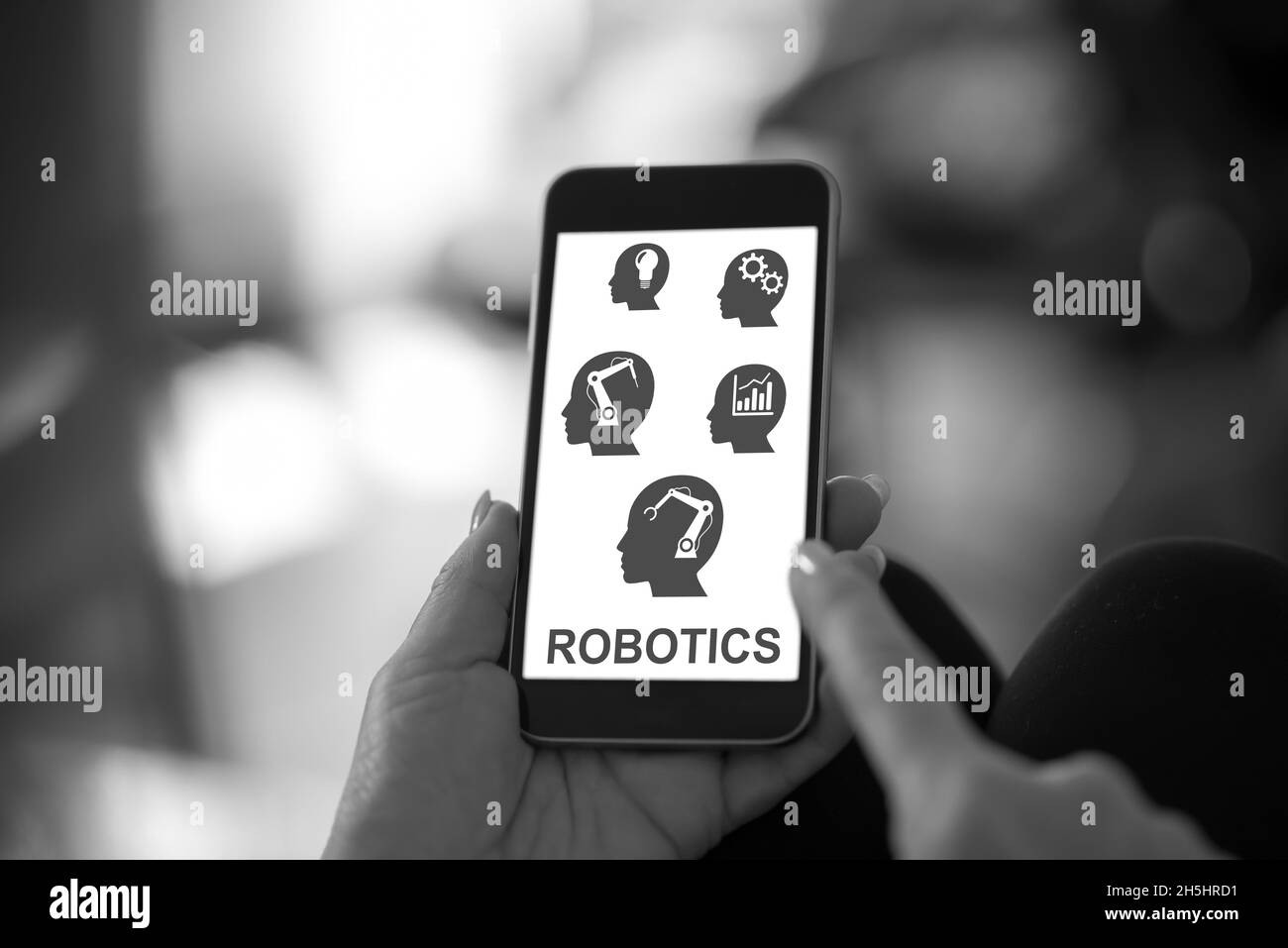 Main tenant un smartphone avec un concept robotique Banque D'Images