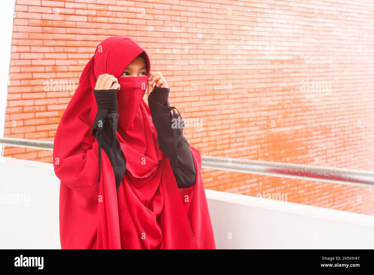 Femme en robe de niqab rouge Banque D'Images