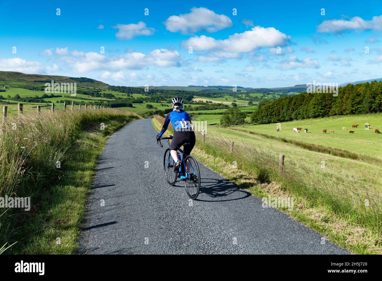 Cycliste sur route féminine lors de sa première balade avec un vélo électrique sur route, Bowland, Lancashire, Royaume-Uni. Banque D'Images