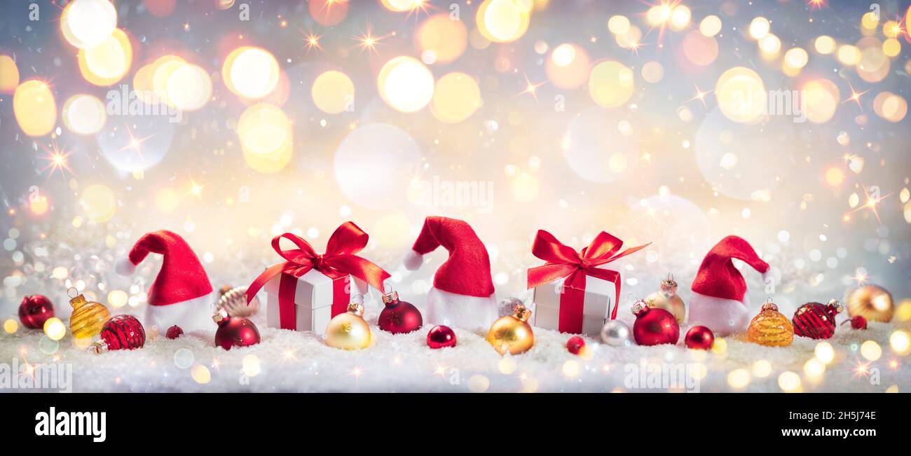 Cadeau de Noël et décoration sur neige avec lumières brillantes dorées - arrière-plan abstrait effet de flou aux couleurs vintage Banque D'Images