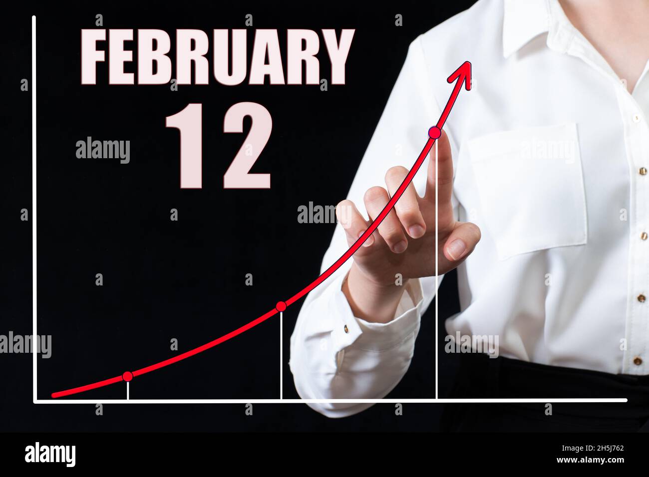 12e jour de février.Main de femme d'affaires pointant vers le graphique et un calendrier avec la date du 12 février.Objectifs commerciaux pour la journée.Mont d'hiver Banque D'Images