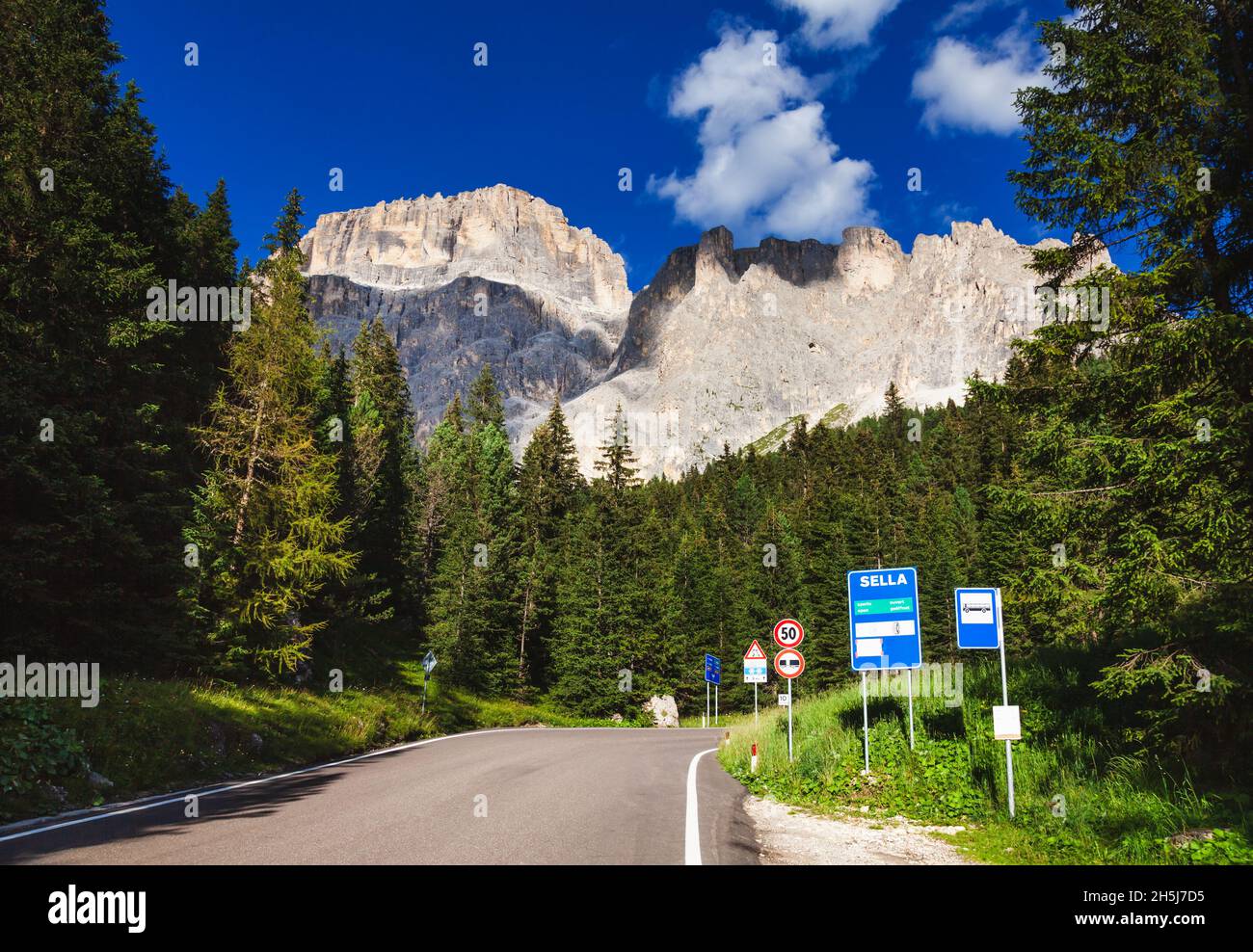 Route pittoresque vers le col de Sella dans les Dolomites, Tyrol du Sud (Sudtirol, Alto Adige), Italie, avec haut mur de roche du groupe de Sella vu en arrière-plan Banque D'Images