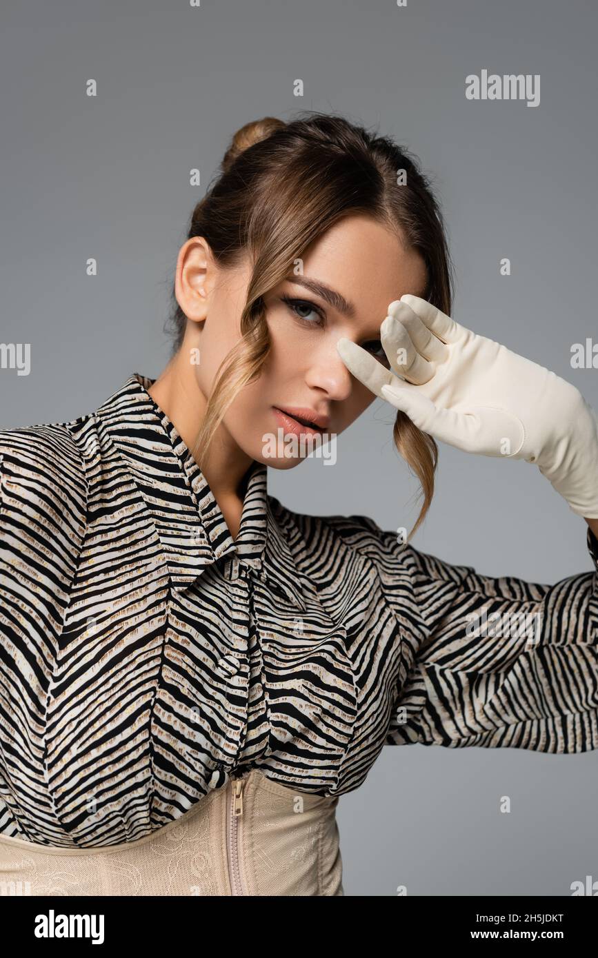 élégante femme en chemisier à imprimé zèbre et gant blanc posé isolé sur le  gris Photo Stock - Alamy