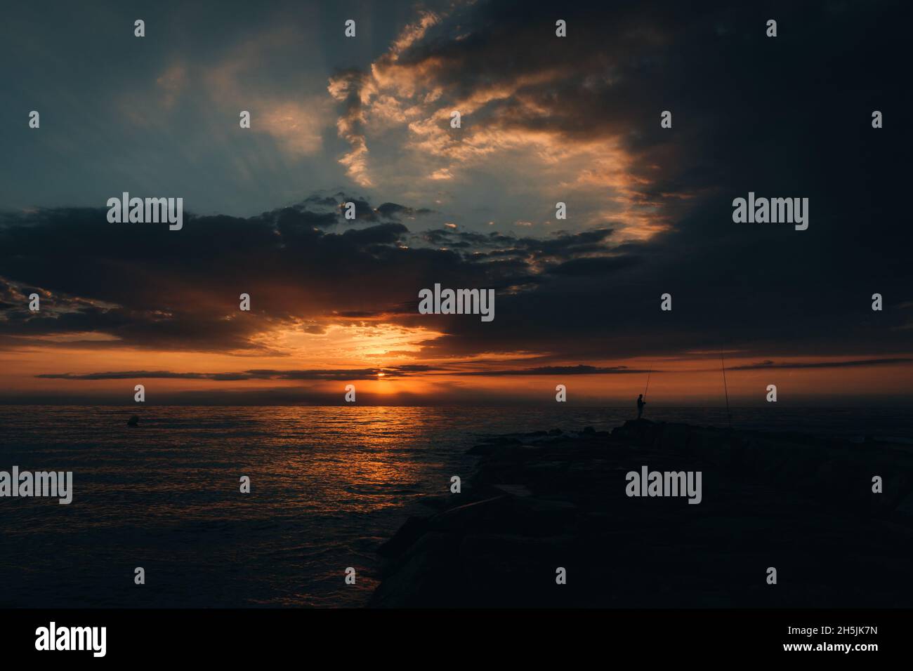 Le lever du soleil et le pêcheur dans le Benicassim, Espagne Banque D'Images