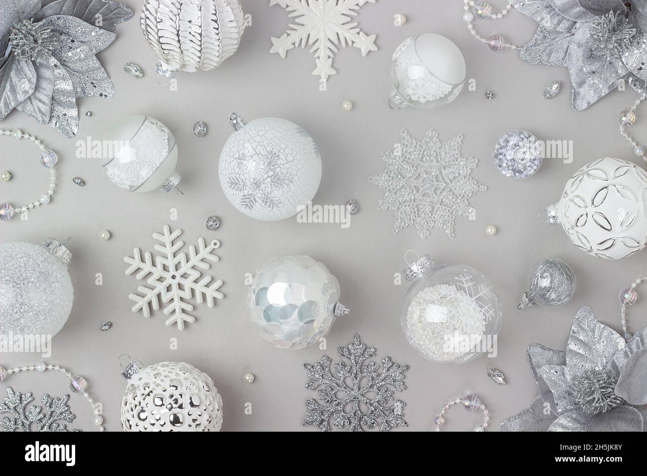 Motif des fêtes fait argent et blanc brillant décorations de noël sur fond gris.Concept joyeux Noël, Noël et nouvel an.Vue de dessus, Flat lay. Banque D'Images