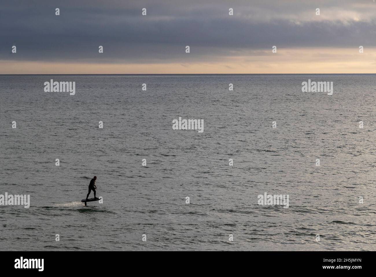 Un homme manne et un panneau de vol stationnaire eFoil à Mounts Bay, Cornwall. Banque D'Images