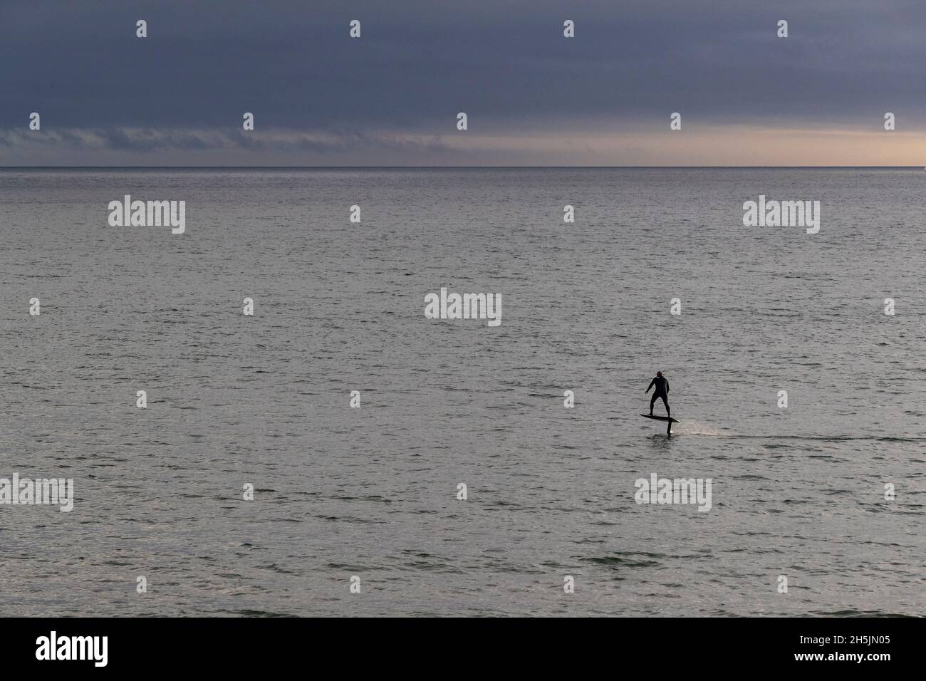 Un homme manne et un panneau de vol stationnaire eFoil à Mounts Bay, Cornwall. Banque D'Images