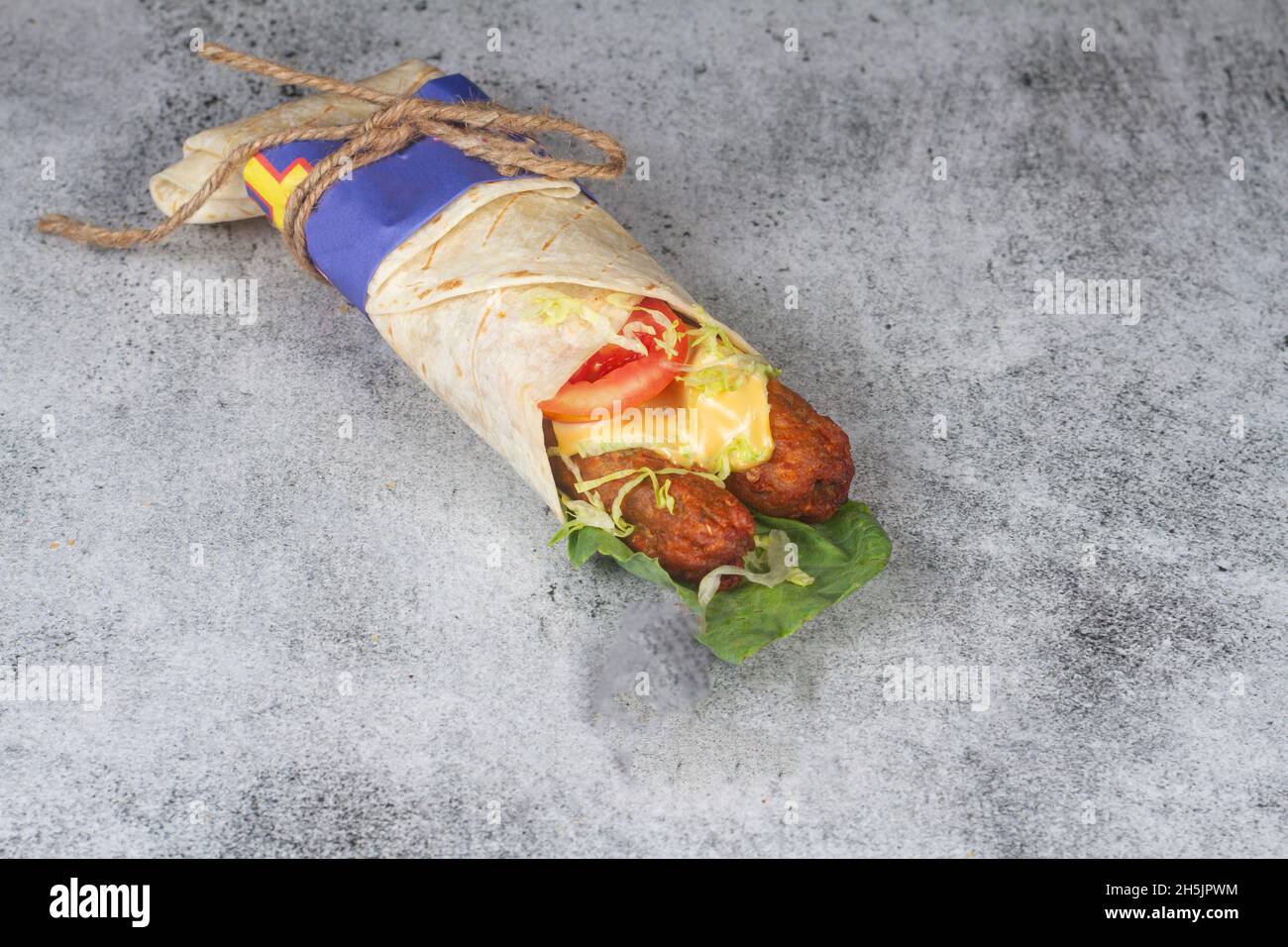 Rouleau de semeskh de poulet frais avec tomates fraîches, salade, fromage et oignons isolés sur fond bleu vif.Mise au point du côté view.selective Banque D'Images