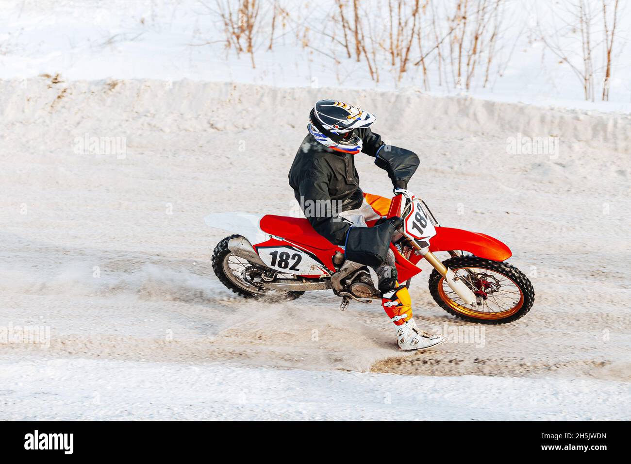 un coureur de motocross d'hiver qui se met en route dans la neige Banque D'Images