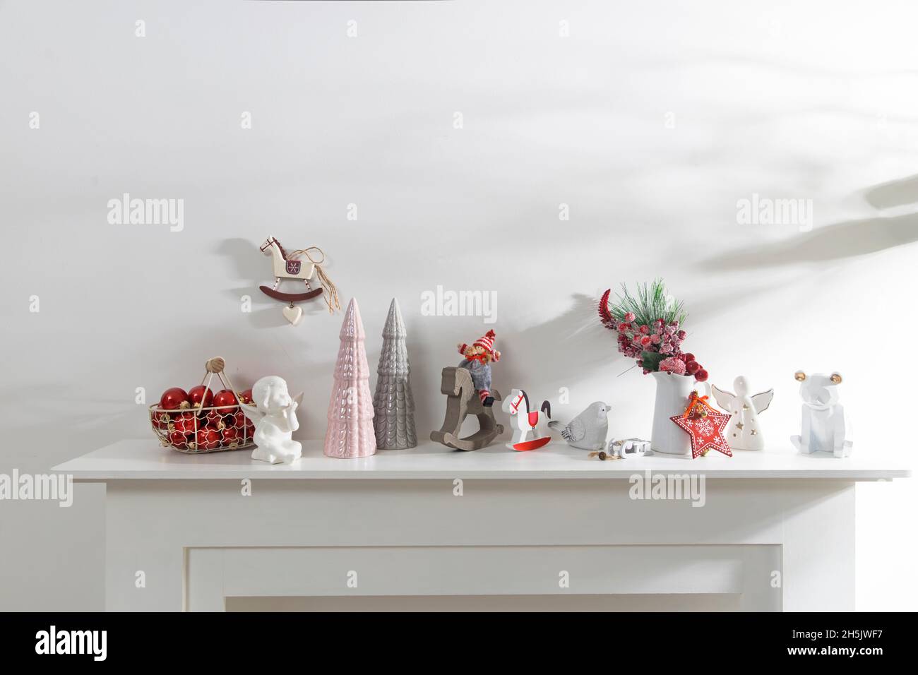 Décoration de l'intérieur de l'appartement pour Noël.Une guirlande de figurines en bois sculpté.Bougies et figurines en céramique sur une fausse cheminée.Copie s Banque D'Images