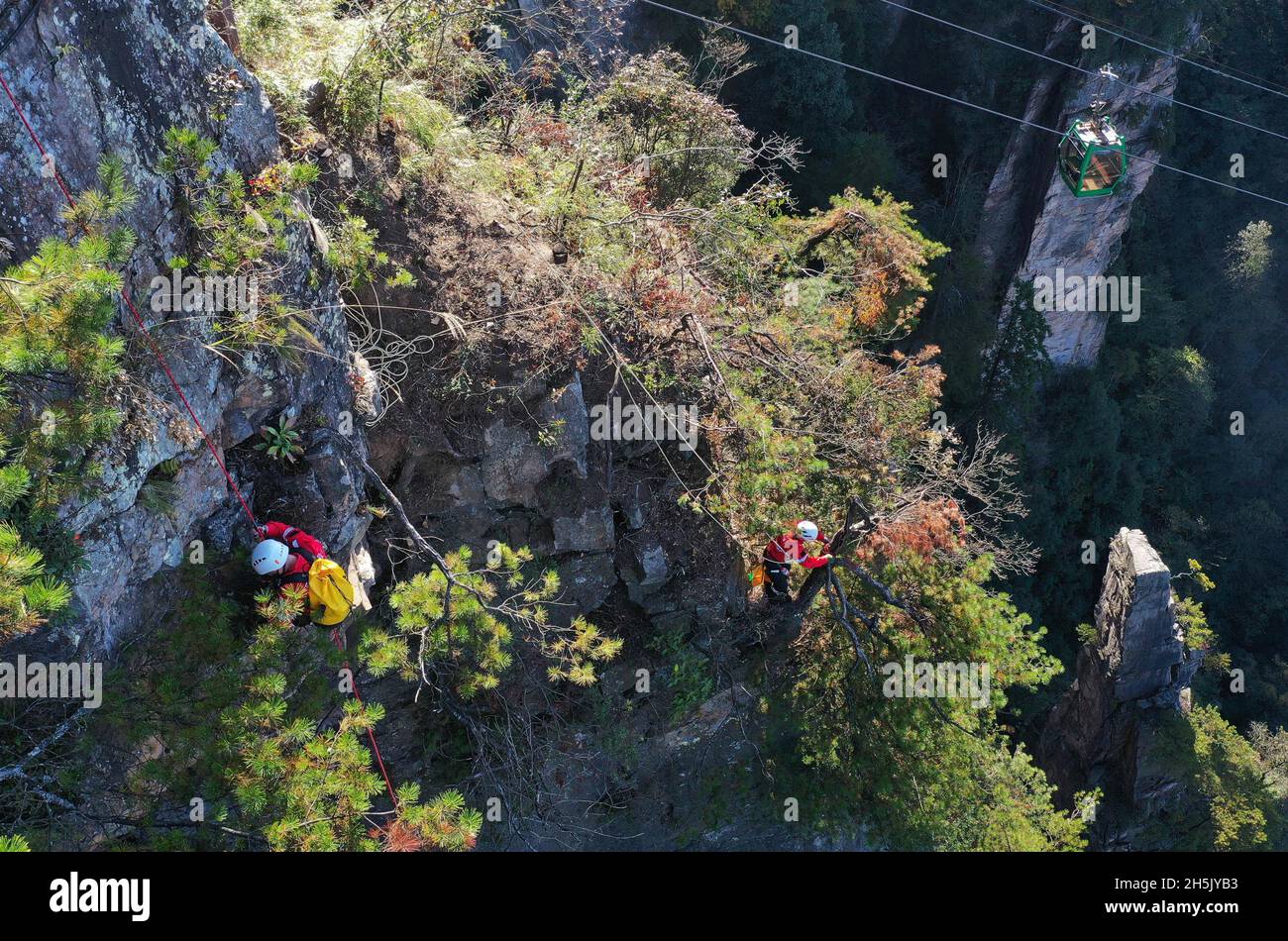 ZHANGJIAJIE, 10 novembre 2021 (Xinhua) -- photo aérienne prise le 10 novembre 2021 montre des membres d'une équipe de secours d'urgence qui ont fait descendre une falaise pour recueillir des litières lors d'un exercice d'urgence au village de Huangshizhai de Wulinguyuan, Zhangjiajie, dans la province du Hunan en Chine centrale.Les membres de cette organisation à but non lucratif collectent régulièrement des litières sur les falaises abruptes de Wulingyuan et de ses environs, site pittoresque inscrit sur la liste du patrimoine naturel mondial de l'UNESCO.(Xinhua/Zhao Zhongzhi) Banque D'Images