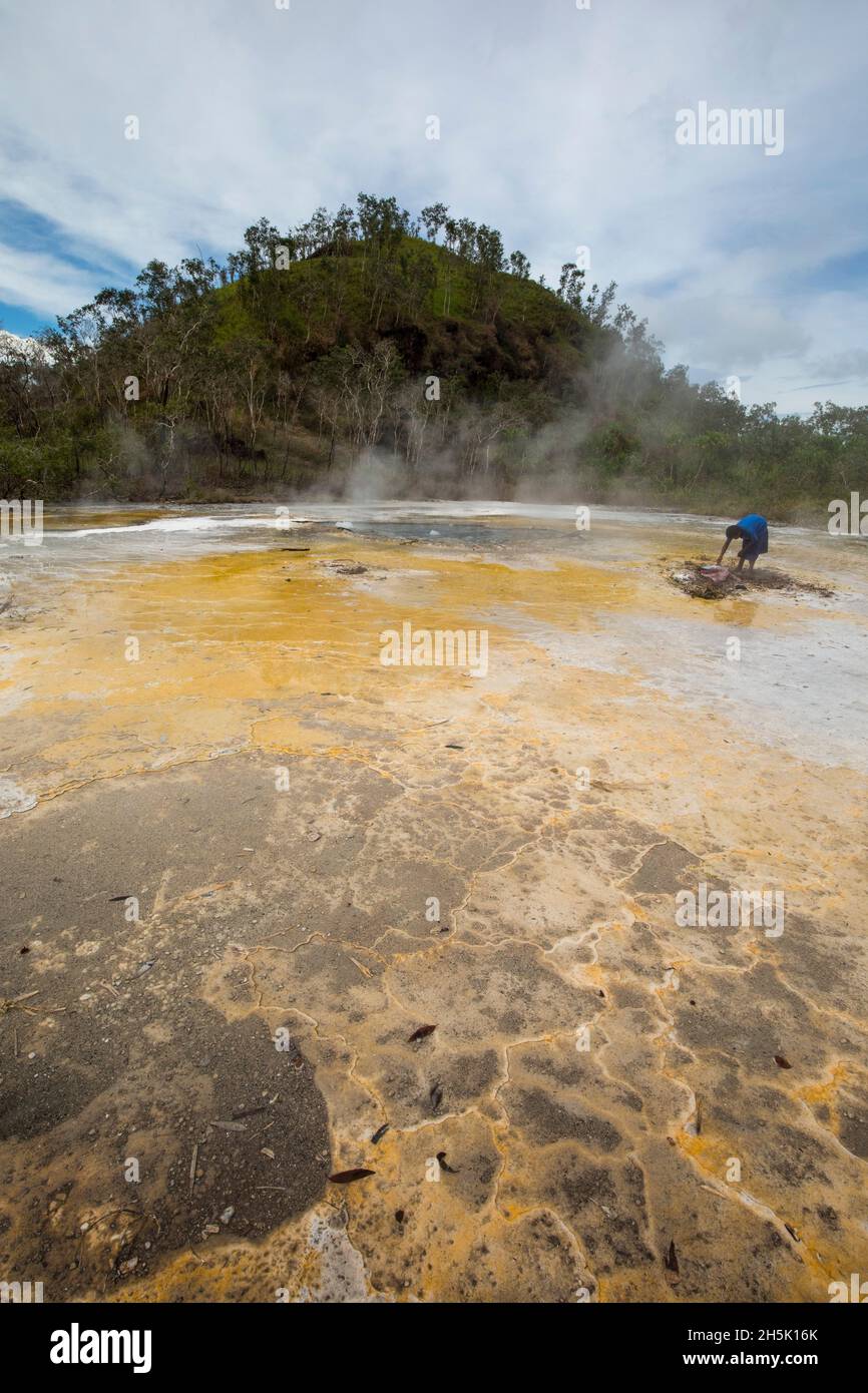 Femme cuisant des ignames dans les sources thermales Dei Dei sur l'île de Fergusson, aux îles d'Entrecasteaux, en Papouasie-Nouvelle-Guinée Banque D'Images