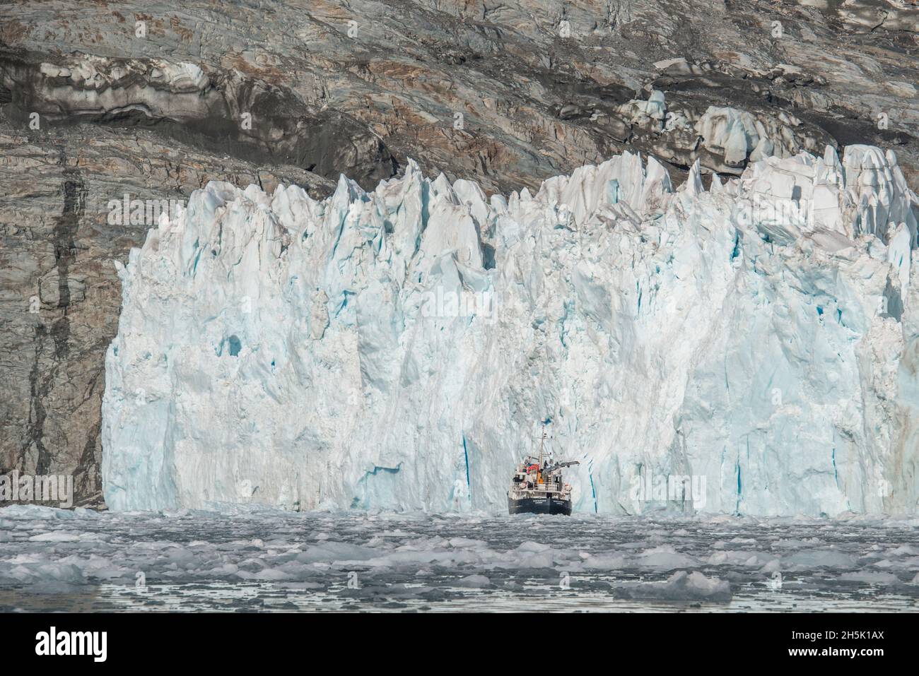 Bateau devant le mur glacé d'un glacier à tidewater sur la rive de l'île de Géorgie du Sud avec l'eau de glace de mer agitée de l'océan Austral Banque D'Images