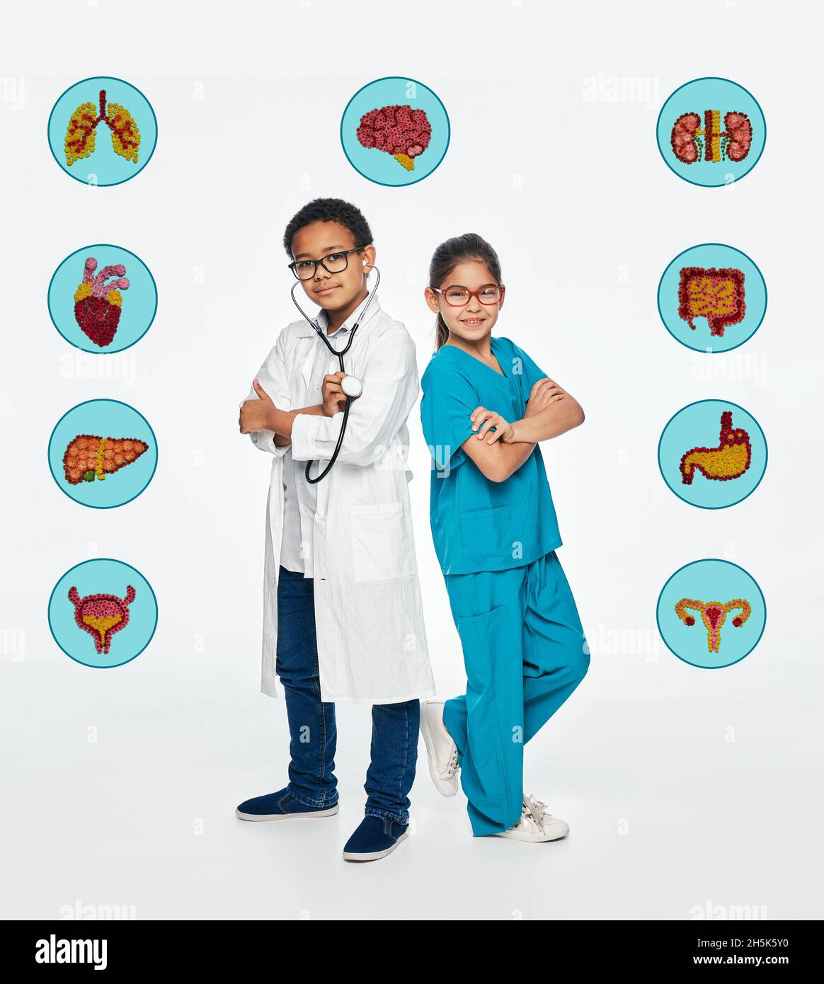 Enfants avec des légumes et des fruits sains près des icônes anatomiques avec des illustrations des organes internes sur fond bleu.Avantages pour la santé de la santé Banque D'Images
