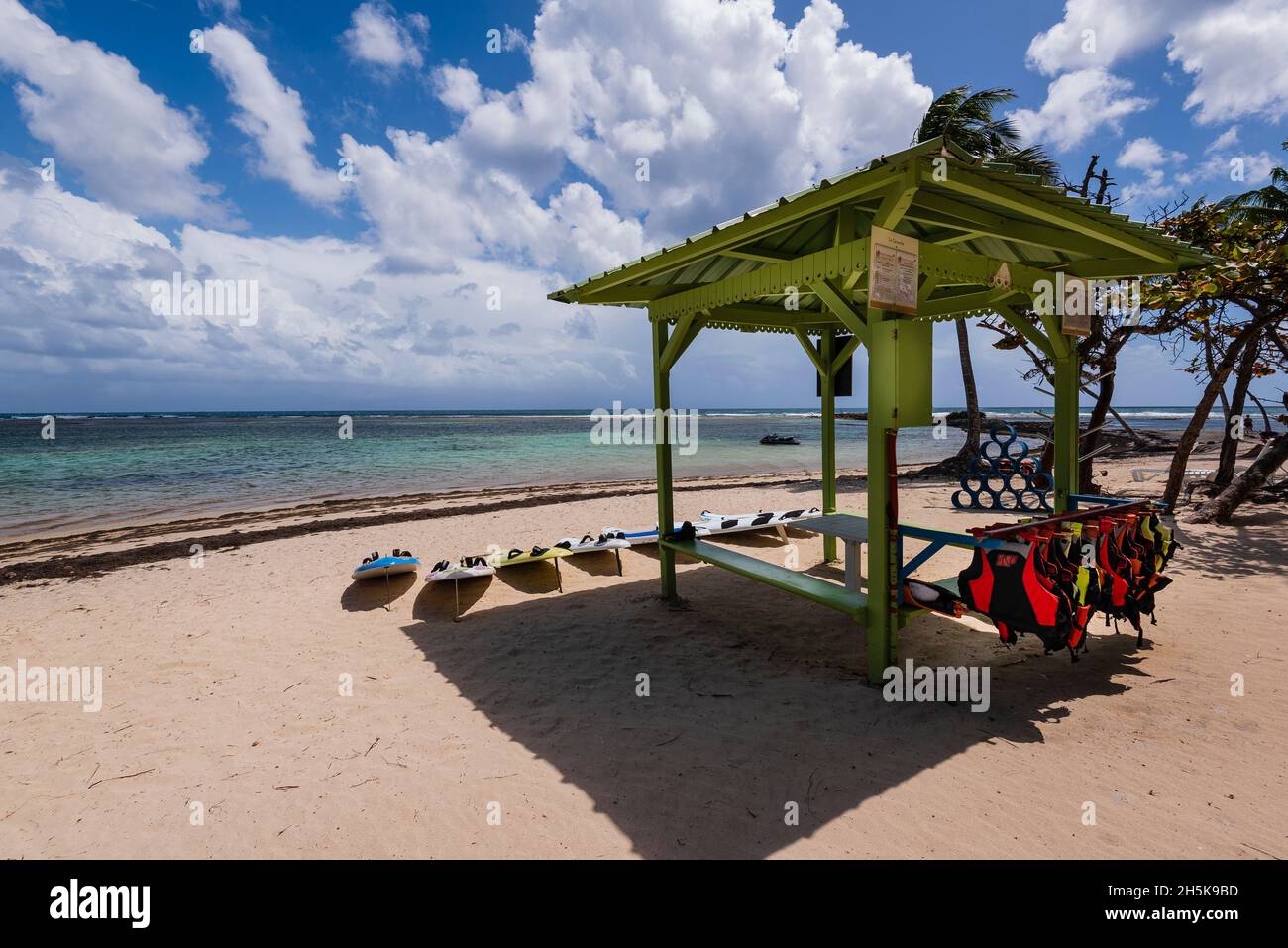 Pavillon avec gilets de sauvetage et planches aquatiques à louer sur la plage de sable de la Caravelle sur les rives de la mer des Caraïbes, Sainte-Anne on G.. Banque D'Images