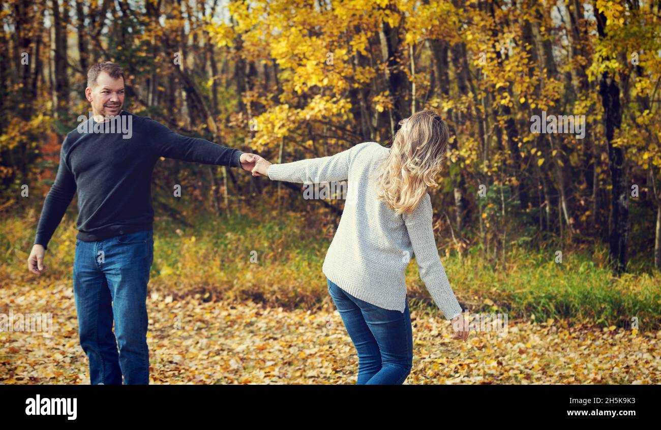 Un couple marié qui passe du temps ensemble de qualité et danse ensemble à l'extérieur dans un parc municipal pendant la saison d'automne; St. Albert, Alberta, Canada Banque D'Images