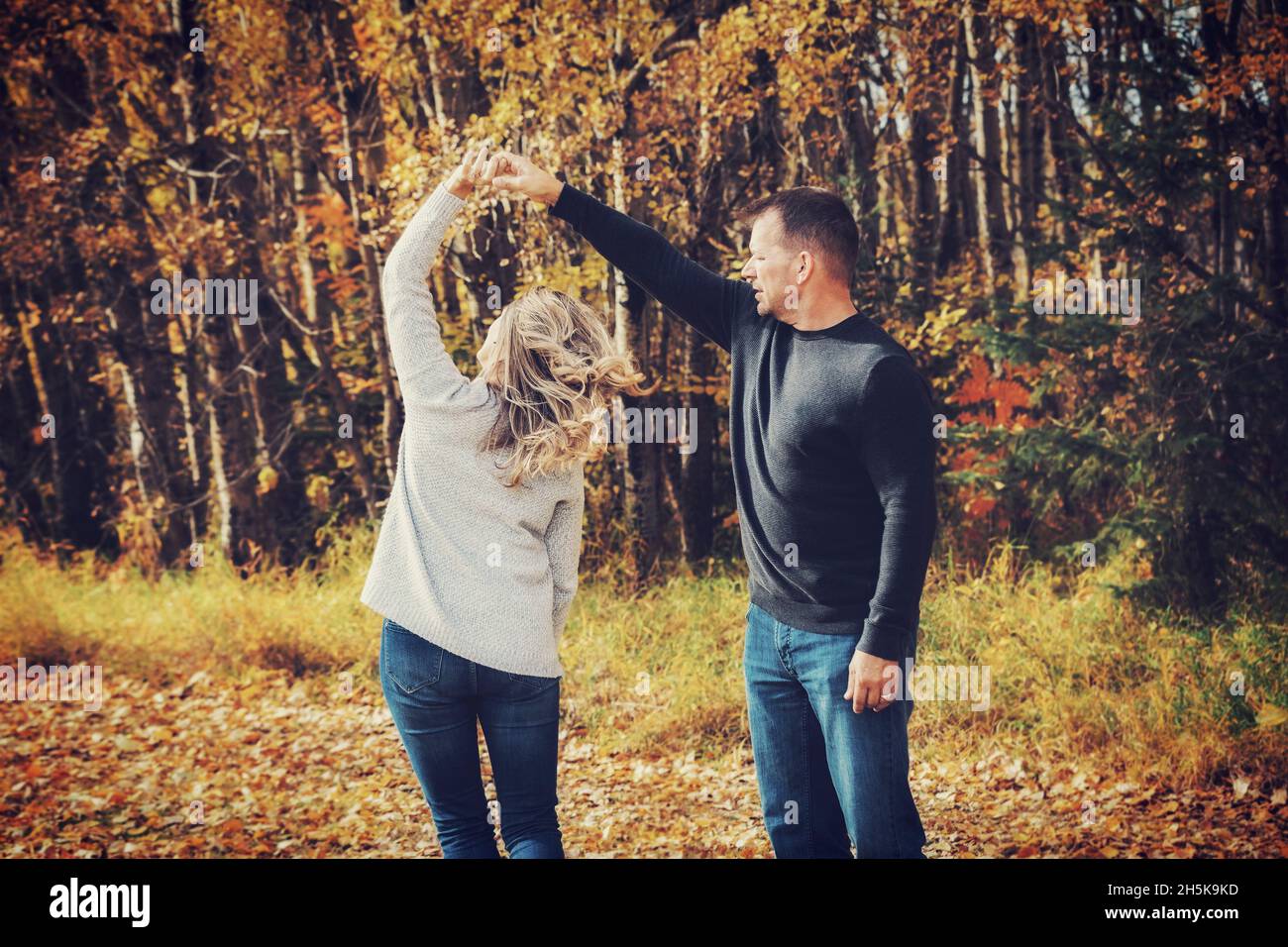 Un couple marié qui passe du temps ensemble de qualité et danse ensemble à l'extérieur dans un parc municipal pendant la saison d'automne; St. Albert, Alberta, Canada Banque D'Images