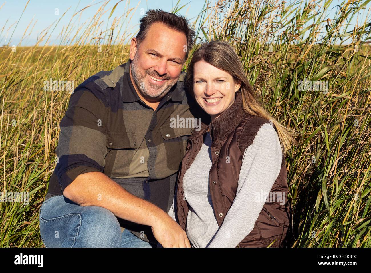 Portrait d'un couple d'âge mûr assis sur un terrain agricole; Alcomdale, Alberta, Canada Banque D'Images