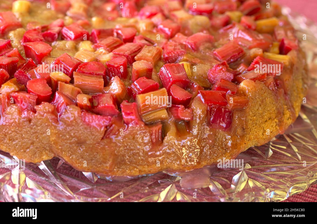 Gâteau renversé à la rhubarbe avec glaçage au sucre brun sur un plateau en cristal. Banque D'Images