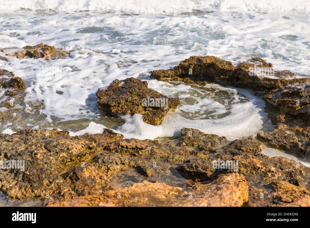 Rock au bord de la mer.Vagues blanches glacielles freinant par les rochers.Image de stock. Banque D'Images