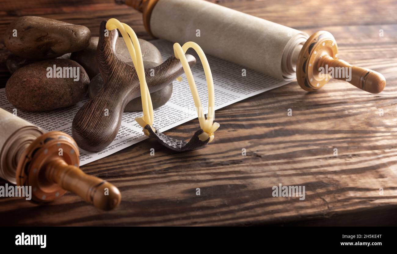 Cinq pierres lisses et un Sling Shot sur un croll hébraïque symbolisant l'histoire de David et Goliath Banque D'Images