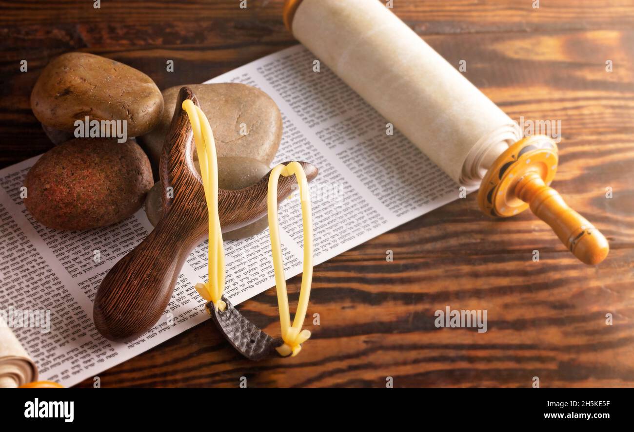 Cinq pierres lisses et un Sling Shot sur un croll hébraïque symbolisant l'histoire de David et Goliath Banque D'Images