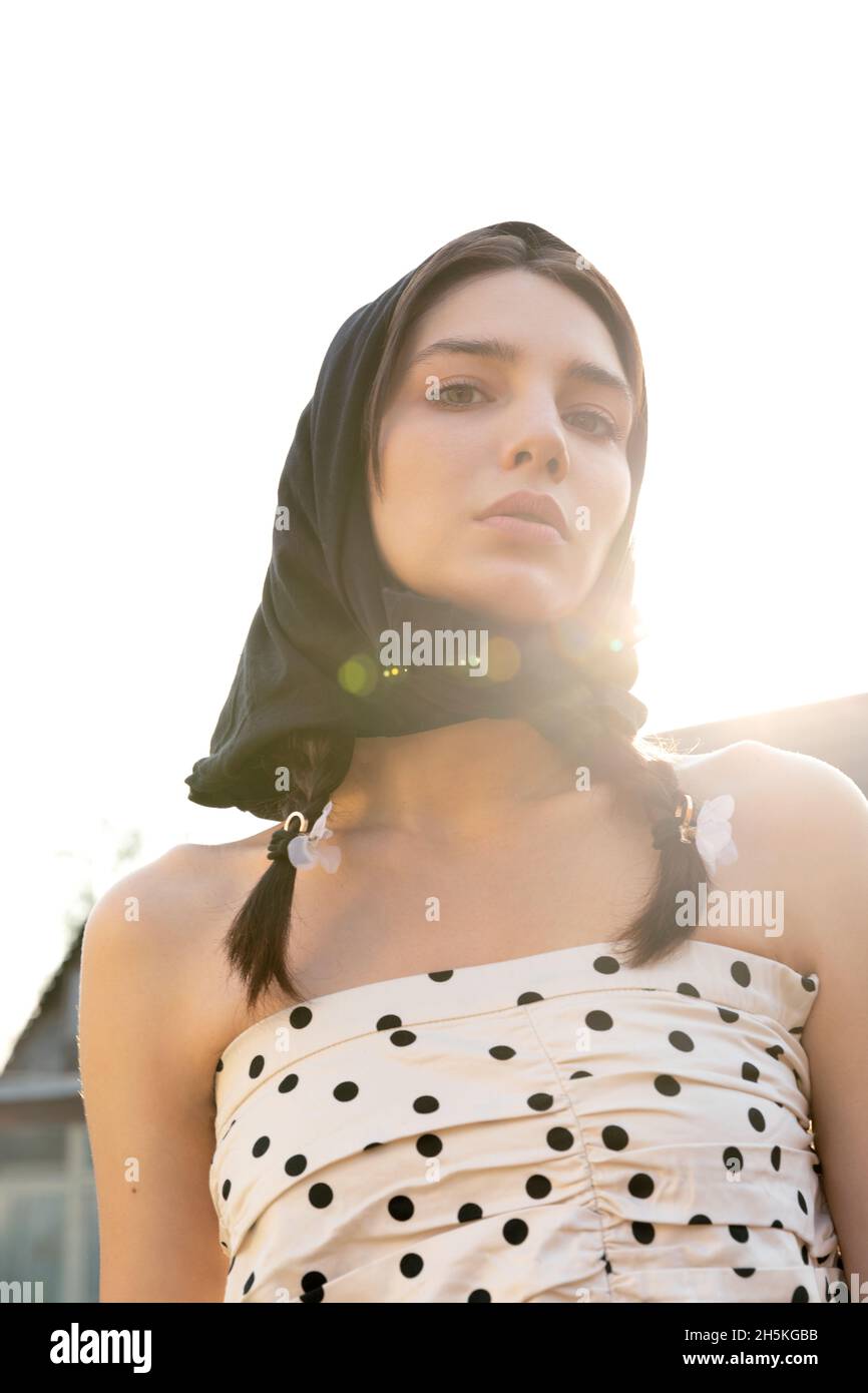 Jeune femme dans un foulard au coucher du soleil. Mode de tournage Banque D'Images