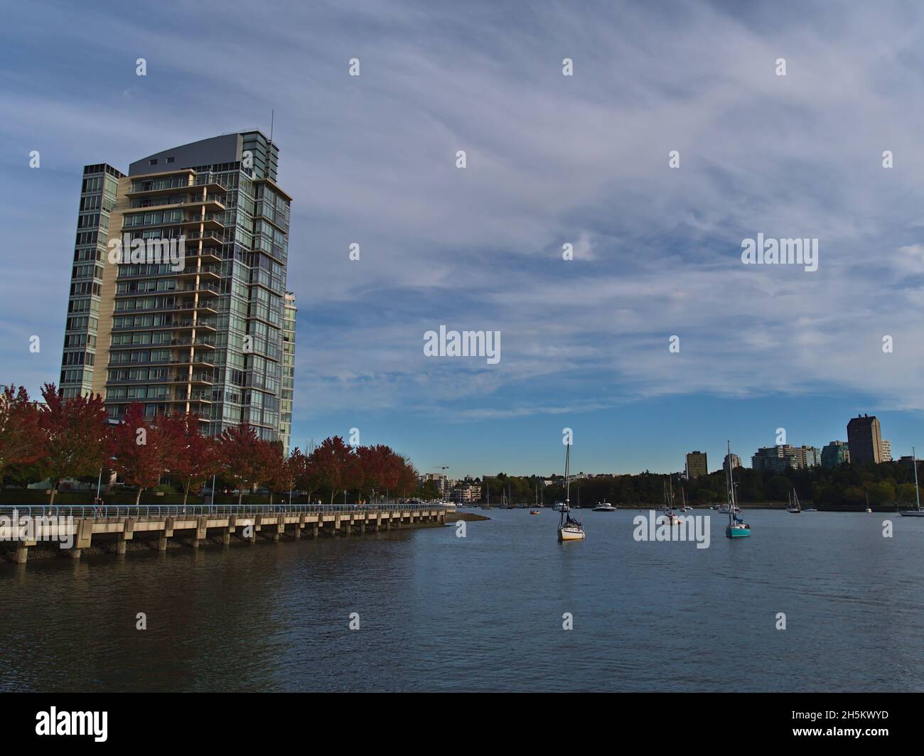 Vue magnifique sur la baie de False Creek, au centre-ville de Vancouver, en Colombie-Britannique, au Canada, avec des bateaux, une promenade, des arbres colorés et des bâtiments résidentiels. Banque D'Images
