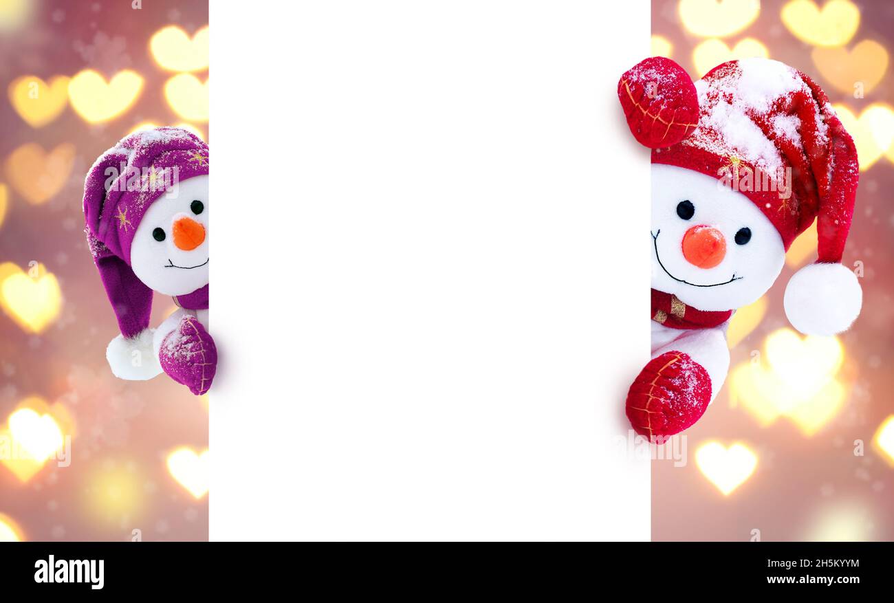 Petits bonhommes de neige en casquettes et en foulards sur fond d'hiver.Décor festif avec des bonhommes de neige amusants.Carte de Noël, espace de copie. Banque D'Images
