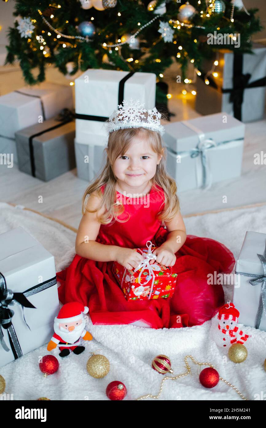 Noël,x-mas,hiver concept - fille en robe rouge fête le nouvel an près de  l'arbre de christmass dans une chambre Photo Stock - Alamy