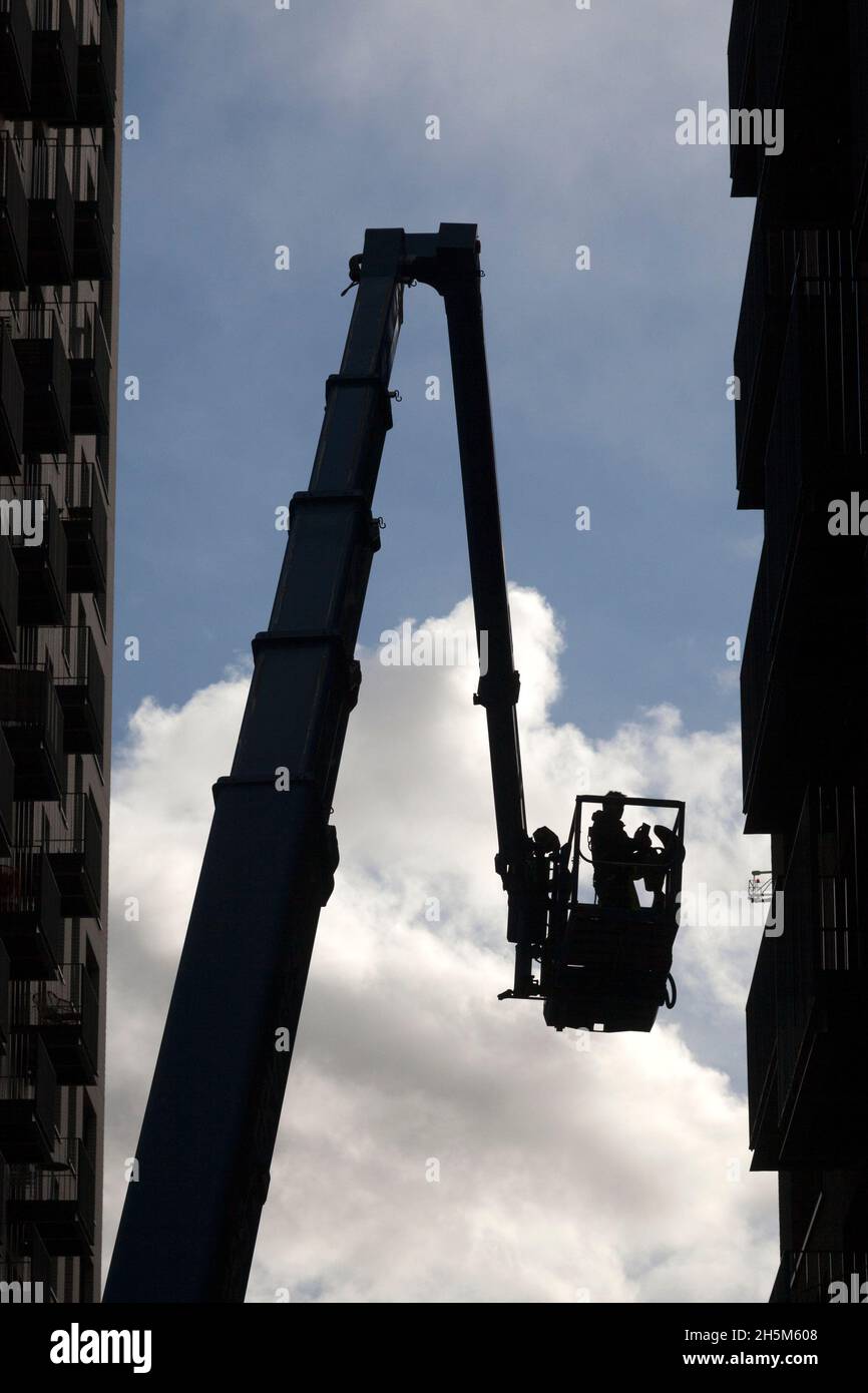 Ingénieur de maintenance travaillant sur un bloc de tour d'un godet de grue, London City Island, Leamouth Peninsula, Londres Banque D'Images