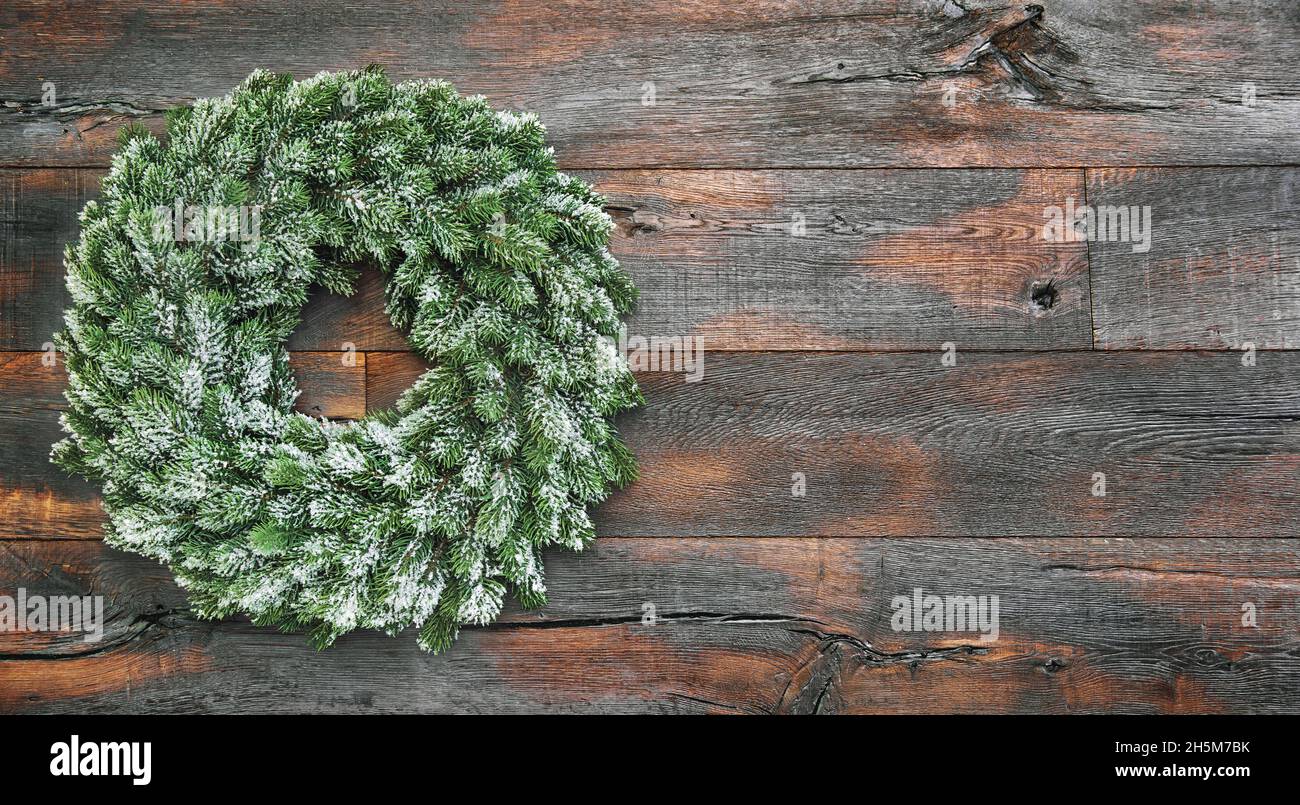 Couronne de Noël enneigée sur fond rustique en bois Banque D'Images