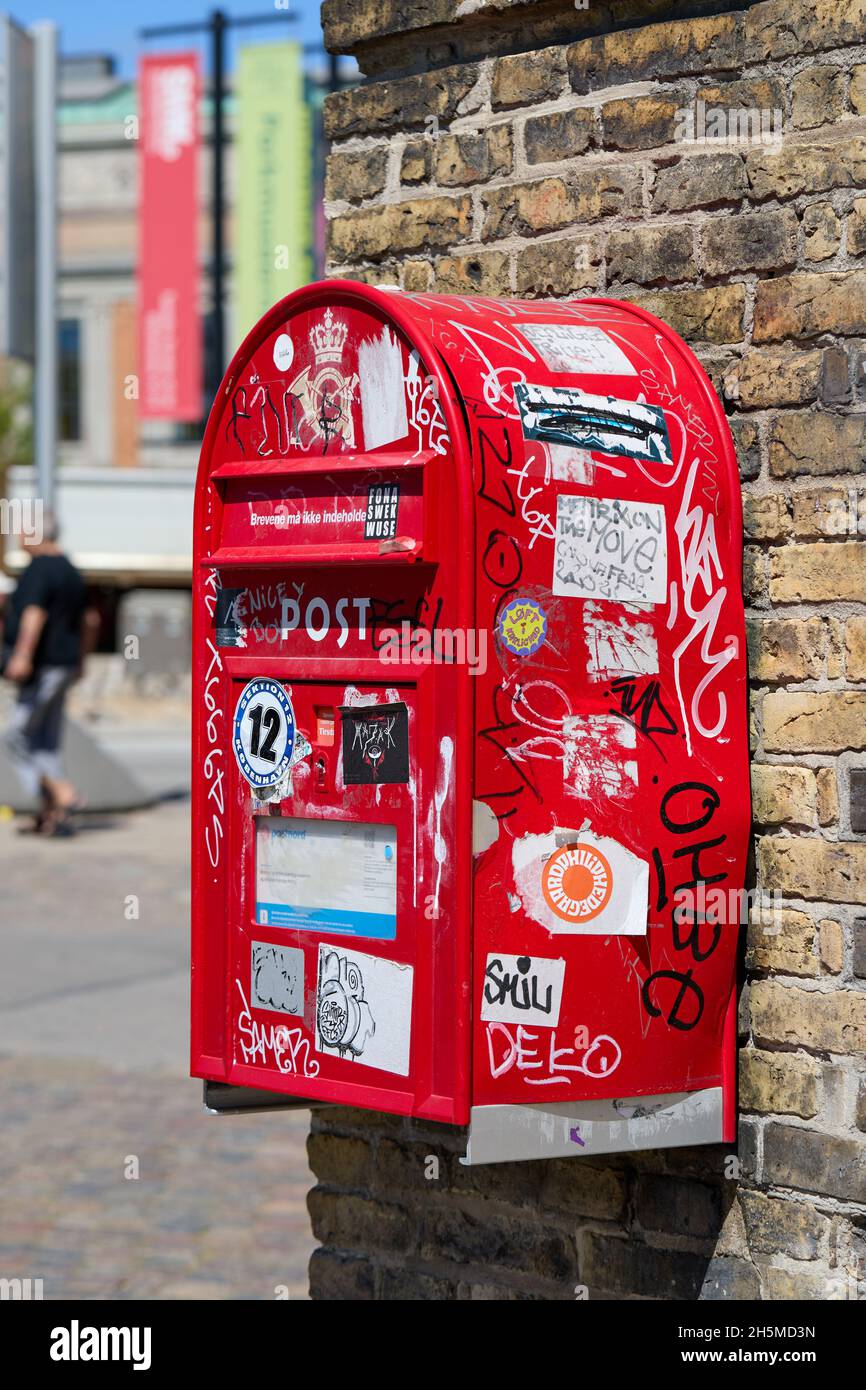 Boîte postale ('postkasse') recouverte d'autocollants et de graffiti; Copenhague, Danemark Banque D'Images