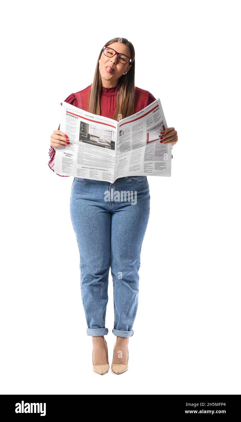 Belle femme en lunettes avec journal montrant la langue sur fond blanc Banque D'Images
