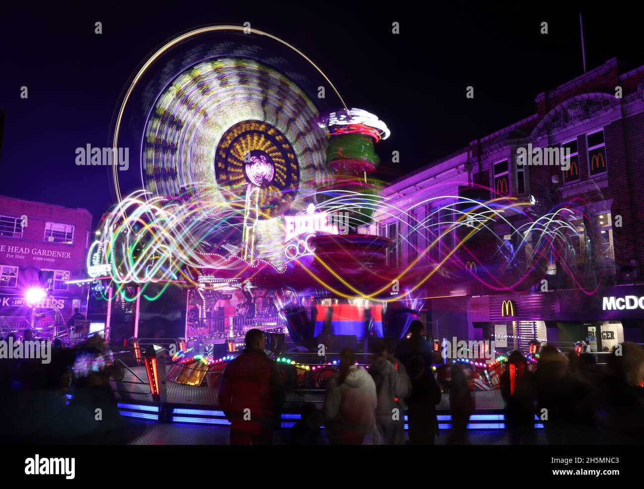 Loughborough, Leicestershire, Royaume-Uni.10 novembre 2021.Les manèges du parc des expositions laissent des sentiers de lumière pendant les célébrations de la 800e année de la foire de rue annuelle.En 1221, un jeune roi Henry III a accordé une charte royale à Hugh le Despenser, le seigneur du manoir, pour tenir un marché hebdomadaire le jeudi et une foire annuelle à Loughborough.Credit Darren Staples/Alay Live News. Banque D'Images