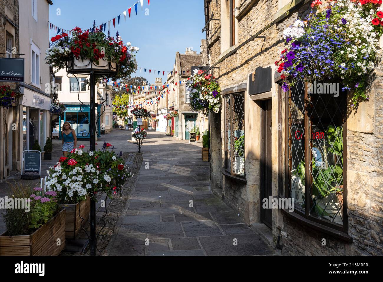 Les boutiques pittoresques en pierre sont décorées de jardinières et de banderoles sur la traditionnelle High Street de Corsham, Wiltshire. Banque D'Images