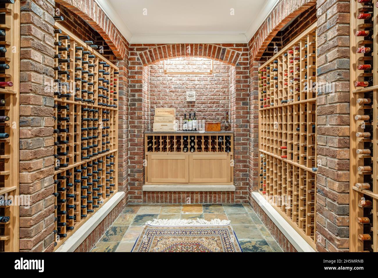 Une grande cave à vin dans une maison de luxe avec des murs en briques et  des casiers à vin en bois Photo Stock - Alamy