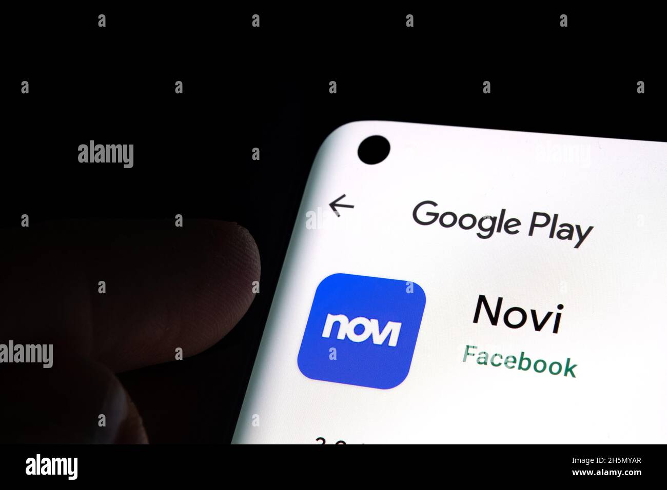 FACEBOOK Novi application portefeuille numérique dans Google Play vu sur l'écran du smartphone et fingerr pointant vers elle.Stafford, Royaume-Uni, 10 novembre 2021 Banque D'Images