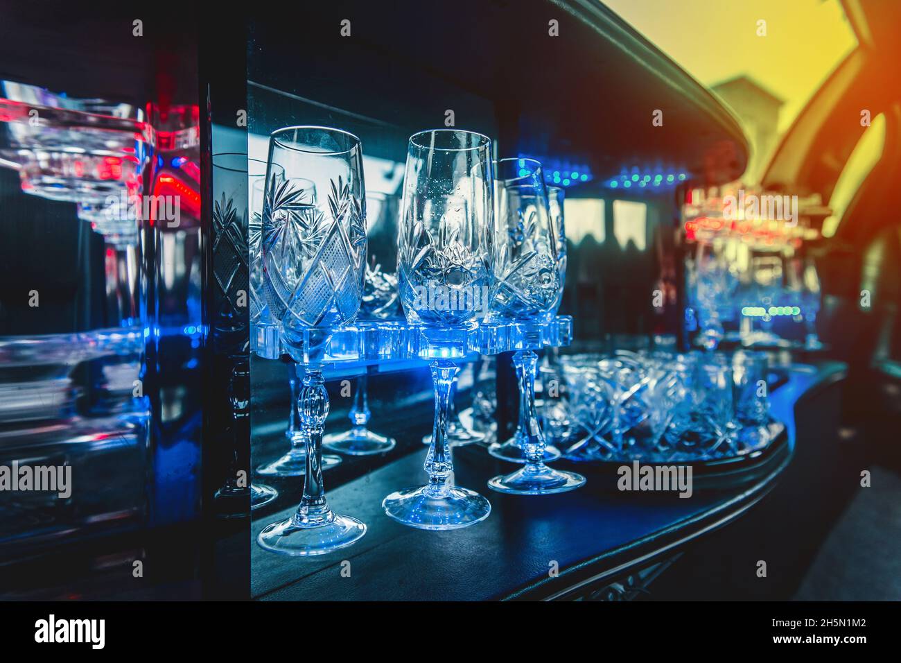 Lunettes en verre avec éclairage au néon à l'intérieur de la luxueuse limousine de voiture. Banque D'Images