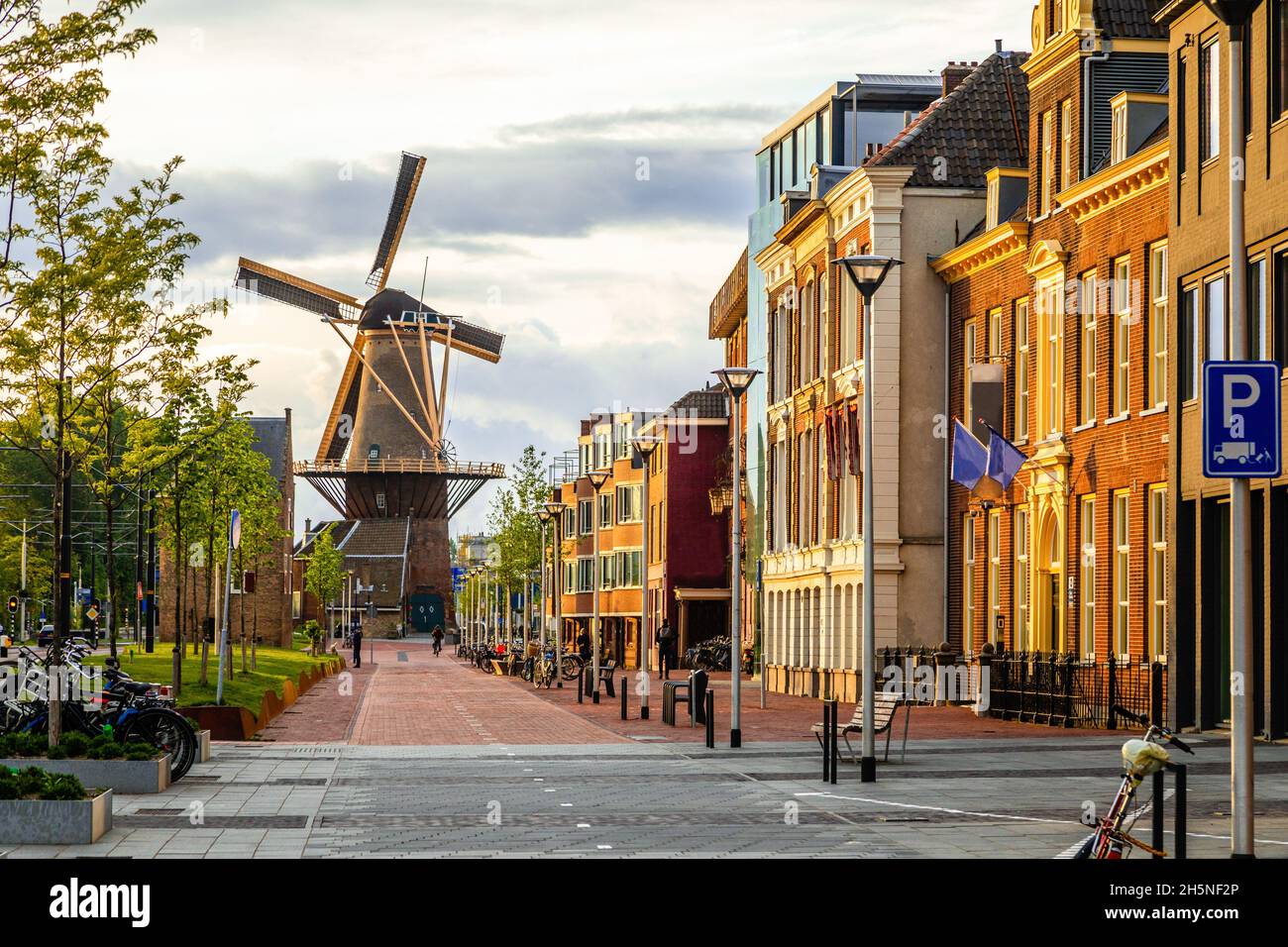 Ancien moulin à vent et rue avec des bâtiments modernes, Delft, pays-Bas Banque D'Images