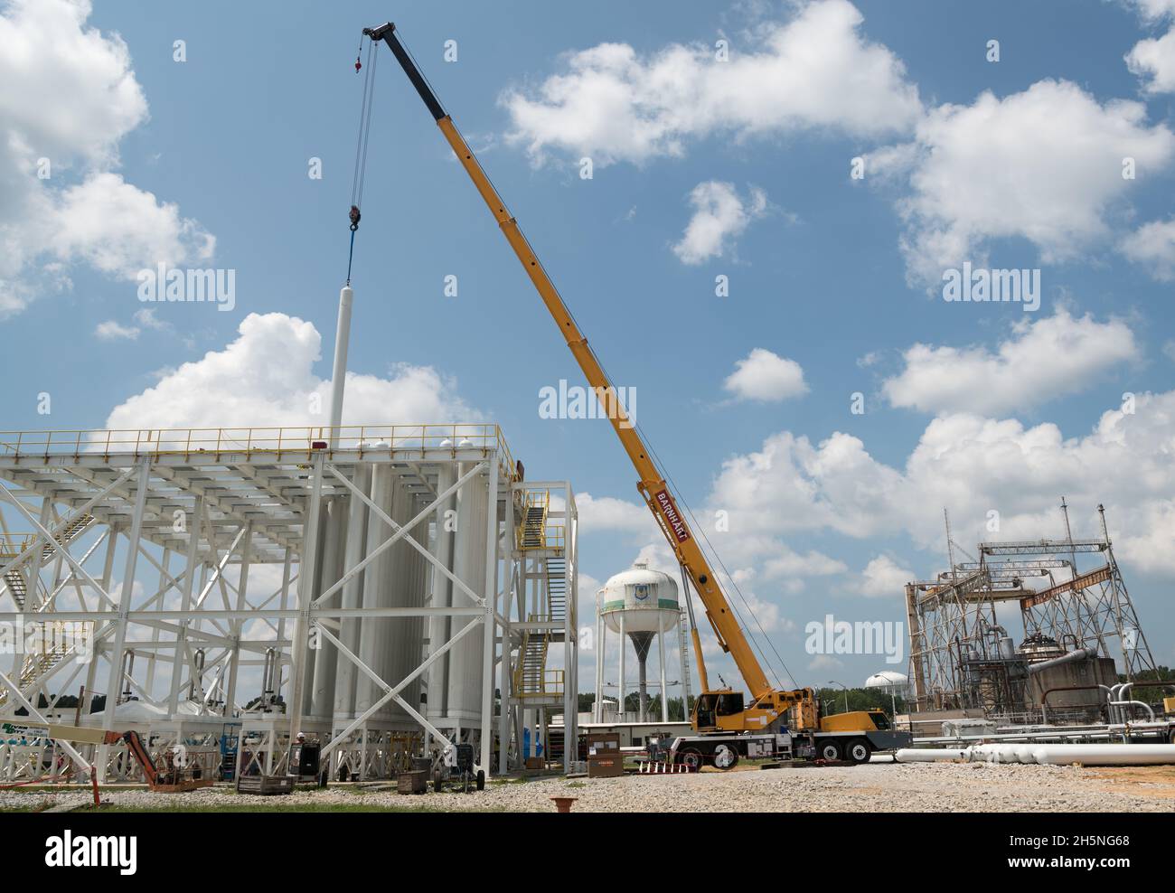 Une bouteille d'air haute pression est soulevée et abaissée en place dans la ferme de bouteilles de l'installation d'essai J-5, le 26 août 2021, à la base aérienne Arnold, au Tennessee. En arrière-plan à droite, se trouve la cellule d'essai du moteur de fusée J-4, qui est actuellement inactive.(É.-U.Photo de la Force aérienne par Jill Pickett) Banque D'Images