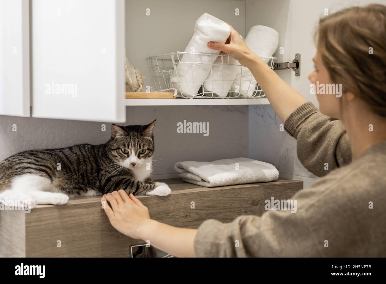Femme mettant ou affichant soigneusement une serviette blanche enroulée propre en coton biologique. Banque D'Images